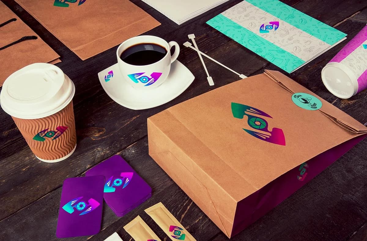 Flat-lay of Capture That Media branded packaging, ripple cups, and purple business cards