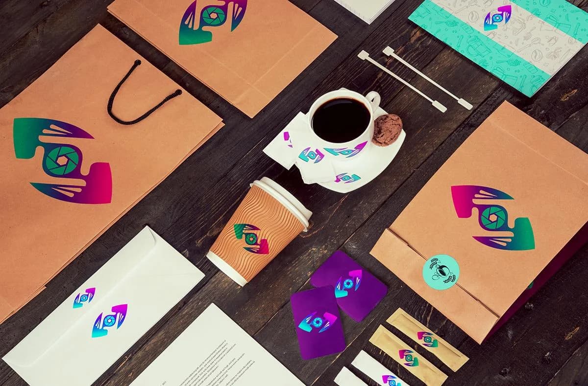 Branded coffee cup, kraft bag, envelope, and business cards in the Capture That Media palette