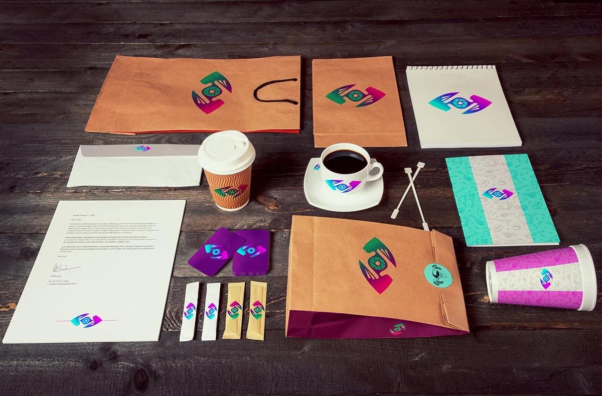 Capture That Media identity system across a full kraft-paper kit — bags, cups, cards, notebook, and stationery carrying the gradient aperture mark