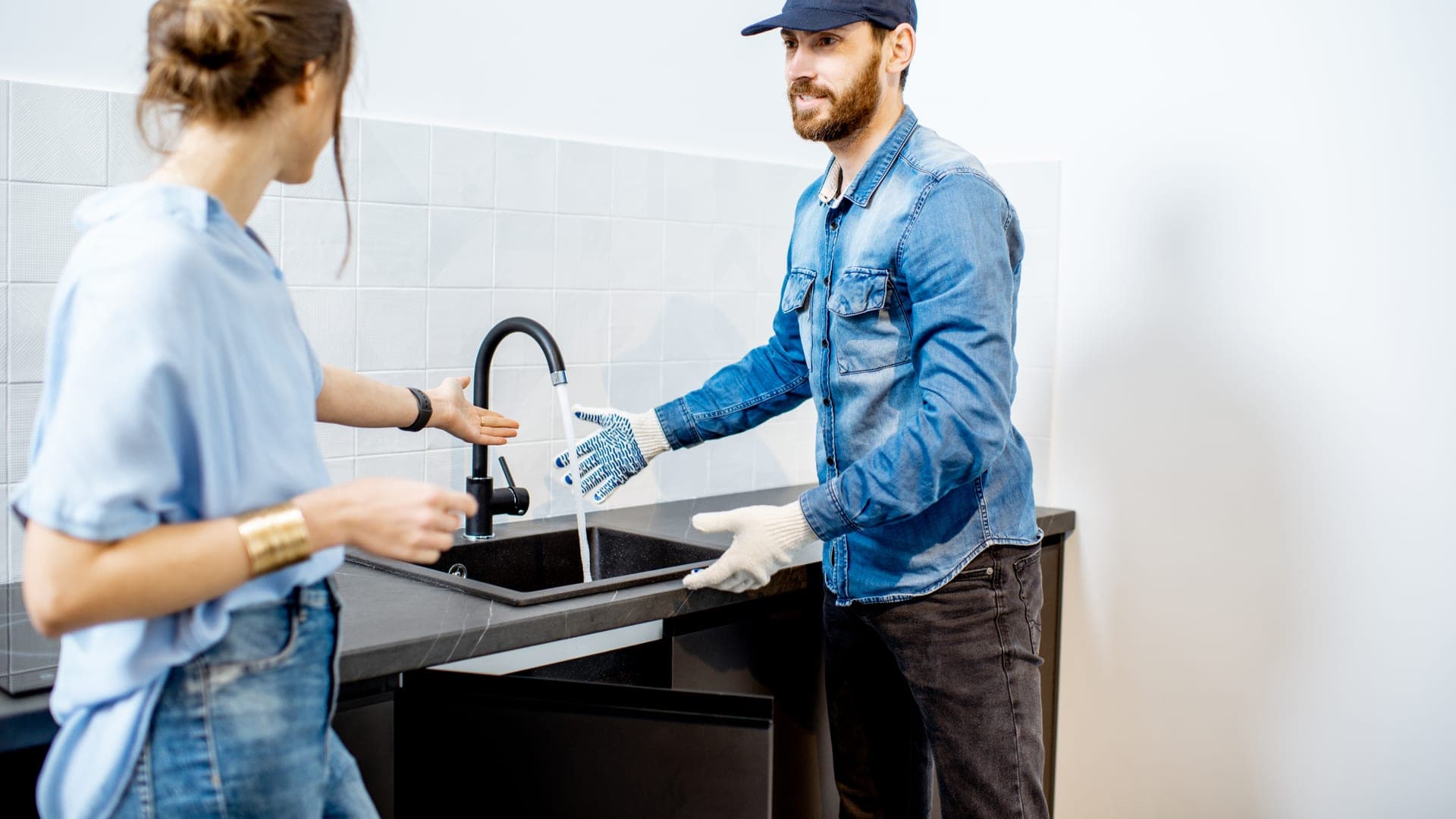 A home-services technician shaking hands with a happy customer after a repair