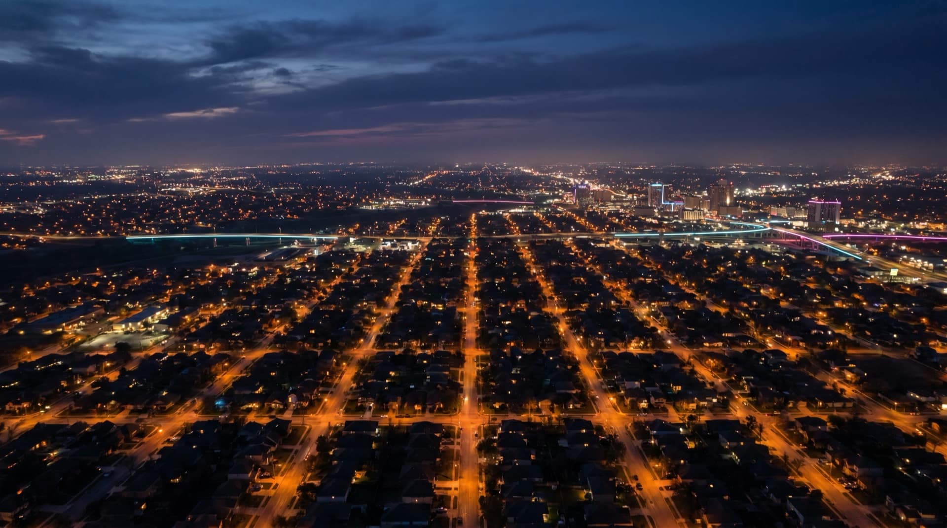An aerial night view of San Antonio neighborhoods glowing across the metro