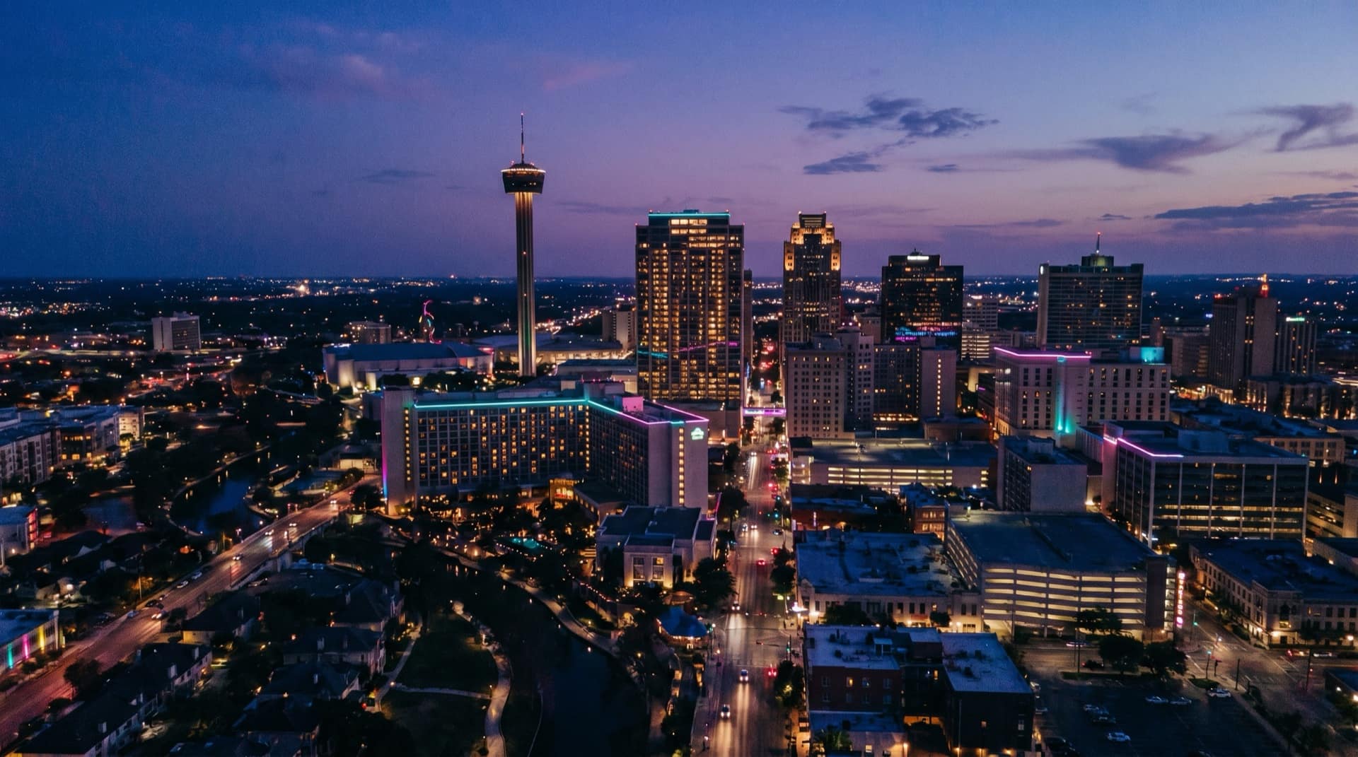 A cinematic blue-hour aerial of San Antonio with the Tower of the Americas