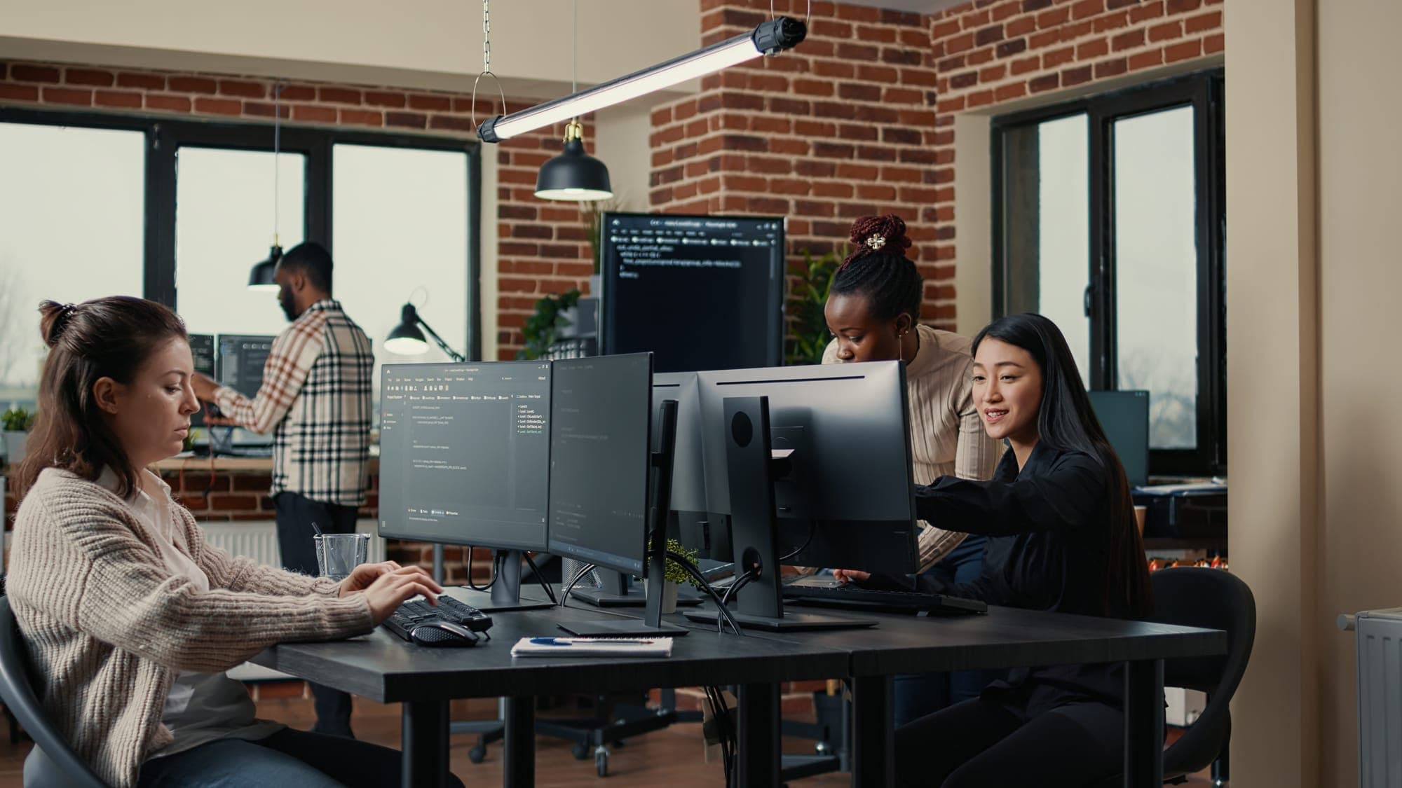A marketing and web team collaborating at their screens in a modern San Antonio studio